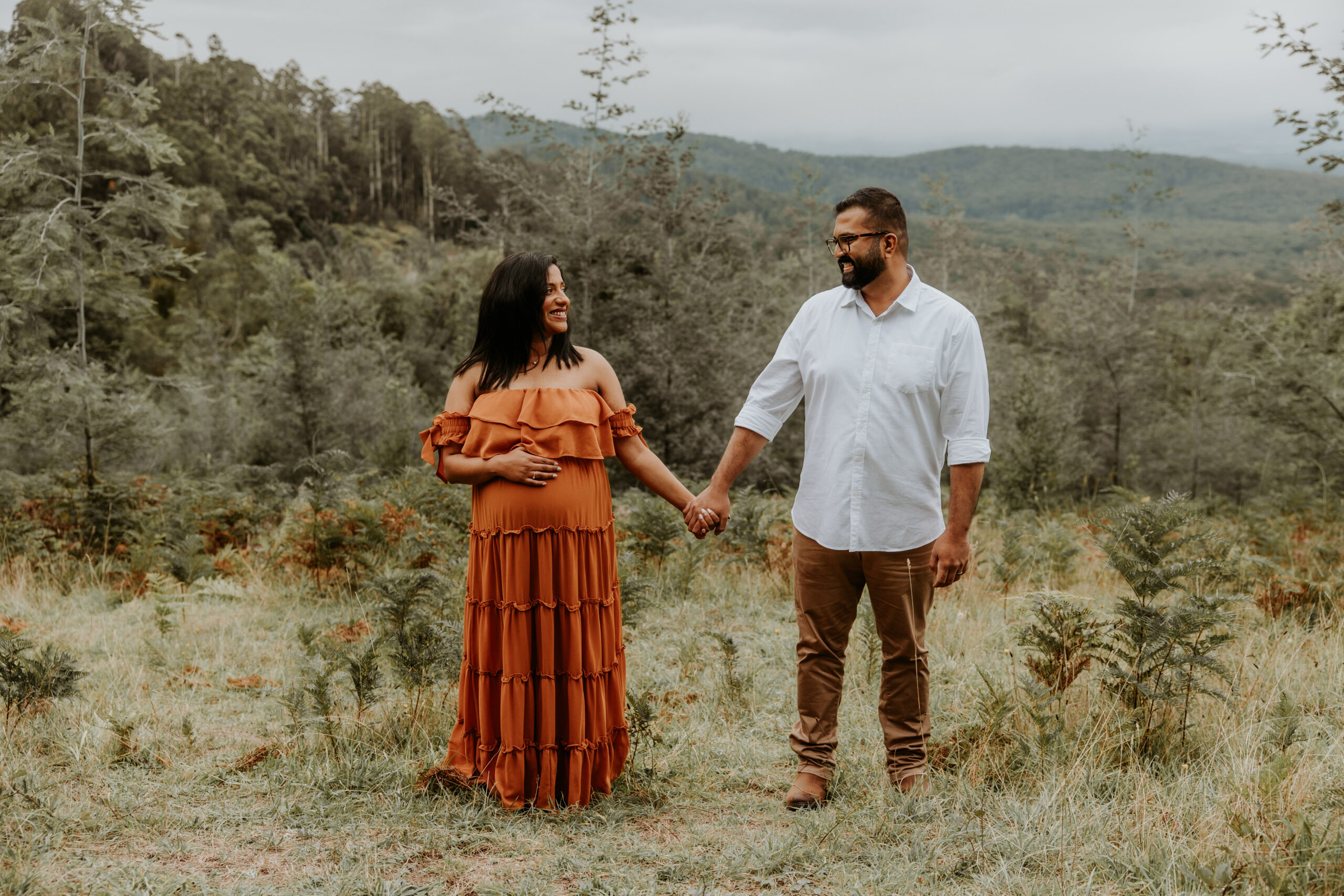 Expectant couple hold hands at outdoor maternity session in Melbourne Dandenong ranges