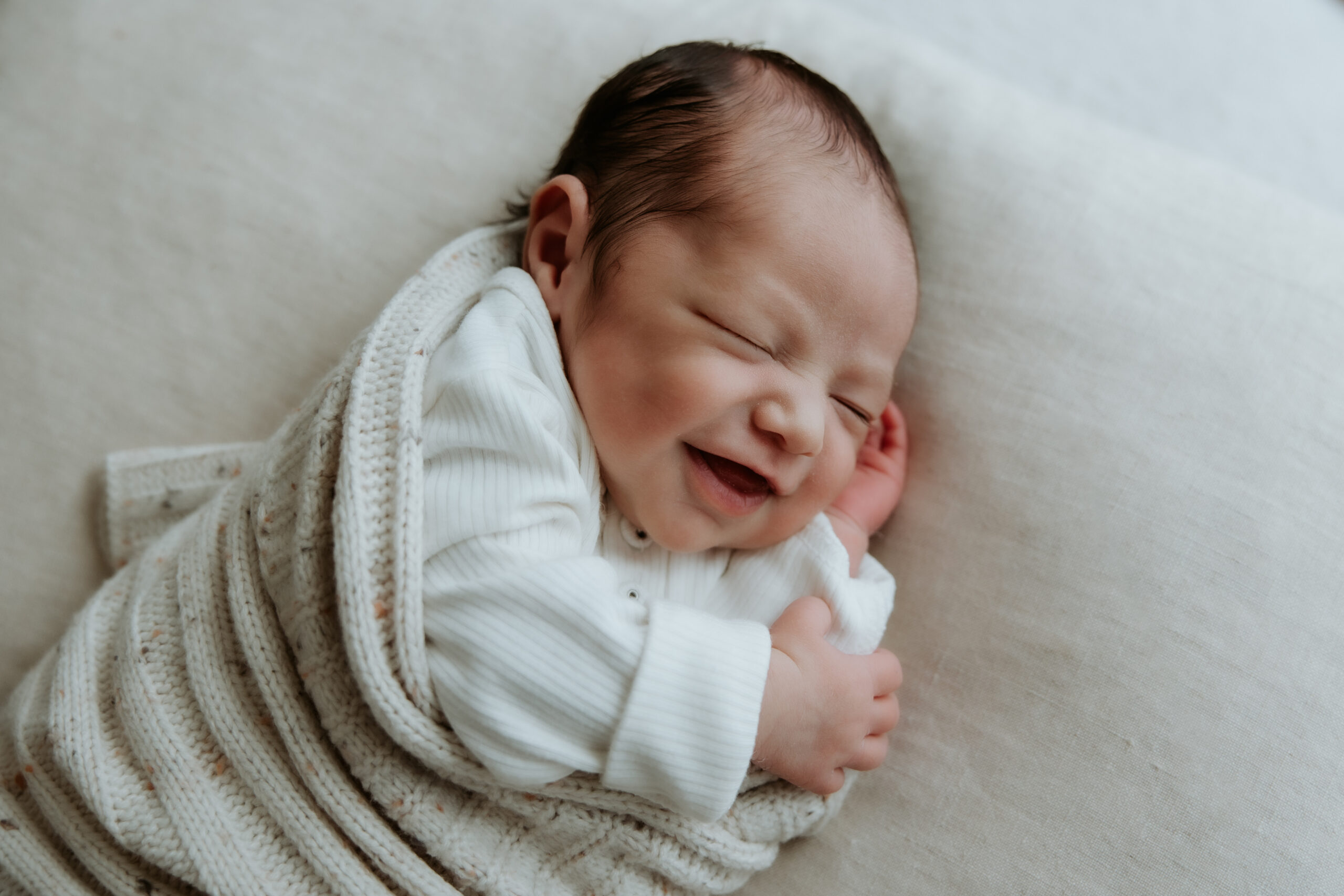 Smiling newborn baby captured during a cosy studio newborn photography session in Melbourne East